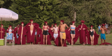 A group of boys throw away their robes at the beach in a scene from the Netflix movie 'Hello, Goodbye, and Everything in Between'