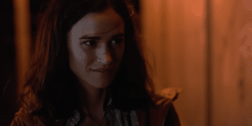 Auden (Emma Pasarow) near a windy beach talking to a boy in the Netflix movie 'Along for the Ride'.