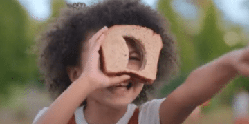 Bean (Madison Skye Validum) playing with a slice of bread in the Netflix movie 'Ivy + Bean: The Ghost That Had to Go'.