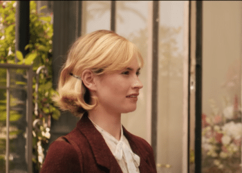 Mrs de Winter (Lily James) talking with a man in the Netflix movie 'Rebecca'.