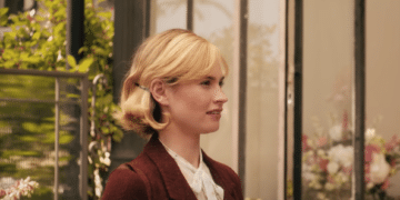 Mrs de Winter (Lily James) talking with a man in the Netflix movie 'Rebecca'.