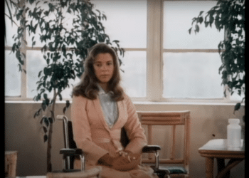 A frame from the movie 'The other Side of the Mountain', in which a character is sitting on a wheelchair.