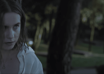 Raqeul (Clara Galle) leaning on a tree in the Netlix movie 'Through My Window'.