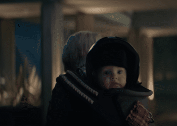 A baby with a motorcycle helmet in the Netflix movie 'A Babysitter's Guide to Monster Hunting'.