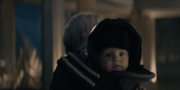 A baby with a motorcycle helmet in the Netflix movie 'A Babysitter's Guide to Monster Hunting'.