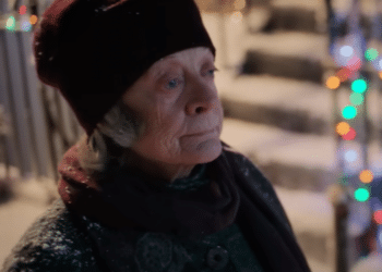 Aunt Ruth (Maggie Smith) walking down a street full of Christmas decorations in the movie 'A Boy Called Christmas'.