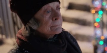 Aunt Ruth (Maggie Smith) walking down a street full of Christmas decorations in the movie 'A Boy Called Christmas'.