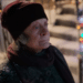 Aunt Ruth (Maggie Smith) walking down a street full of Christmas decorations in the movie 'A Boy Called Christmas'.