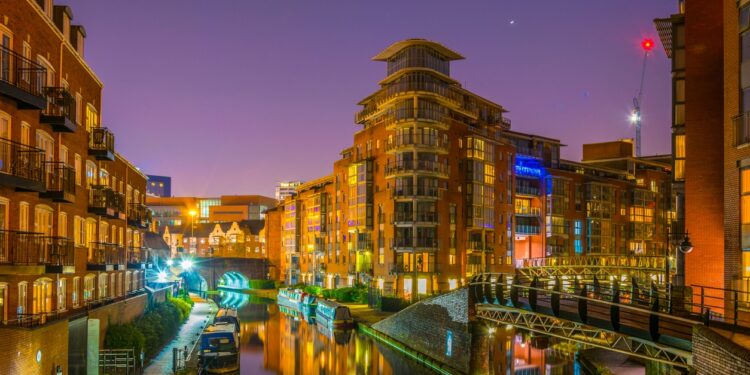 Night view of brick buildings alongside a water channel in the central Birmingham, England