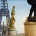Statues on a the Trocadero esplanade with a woman's legs climbing on it. Eiffel Tower in the background.