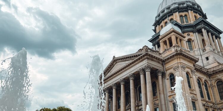 Ornamental water fountain on the grounds of the Illinois State Capitol Complex in Springfield, IL, USA. The majestic Illinois State Capitol Building stands tall in the background.