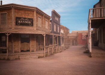 Empty dirt street in an old western town with various wooden buildings. 3D rendering.