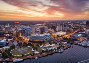 Norfolk, Virginia, USA downtown city skyline from over the Elizabeth River at dusk.
