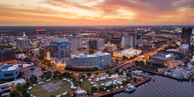 Norfolk, Virginia, USA downtown city skyline from over the Elizabeth River at dusk.
