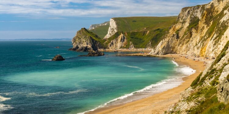 Jurassic coastline with bright blue green sea, deep blue skies and yellow sands and cliffs around the Lulworth, Durdle Door, Worbarrow beaches and coves